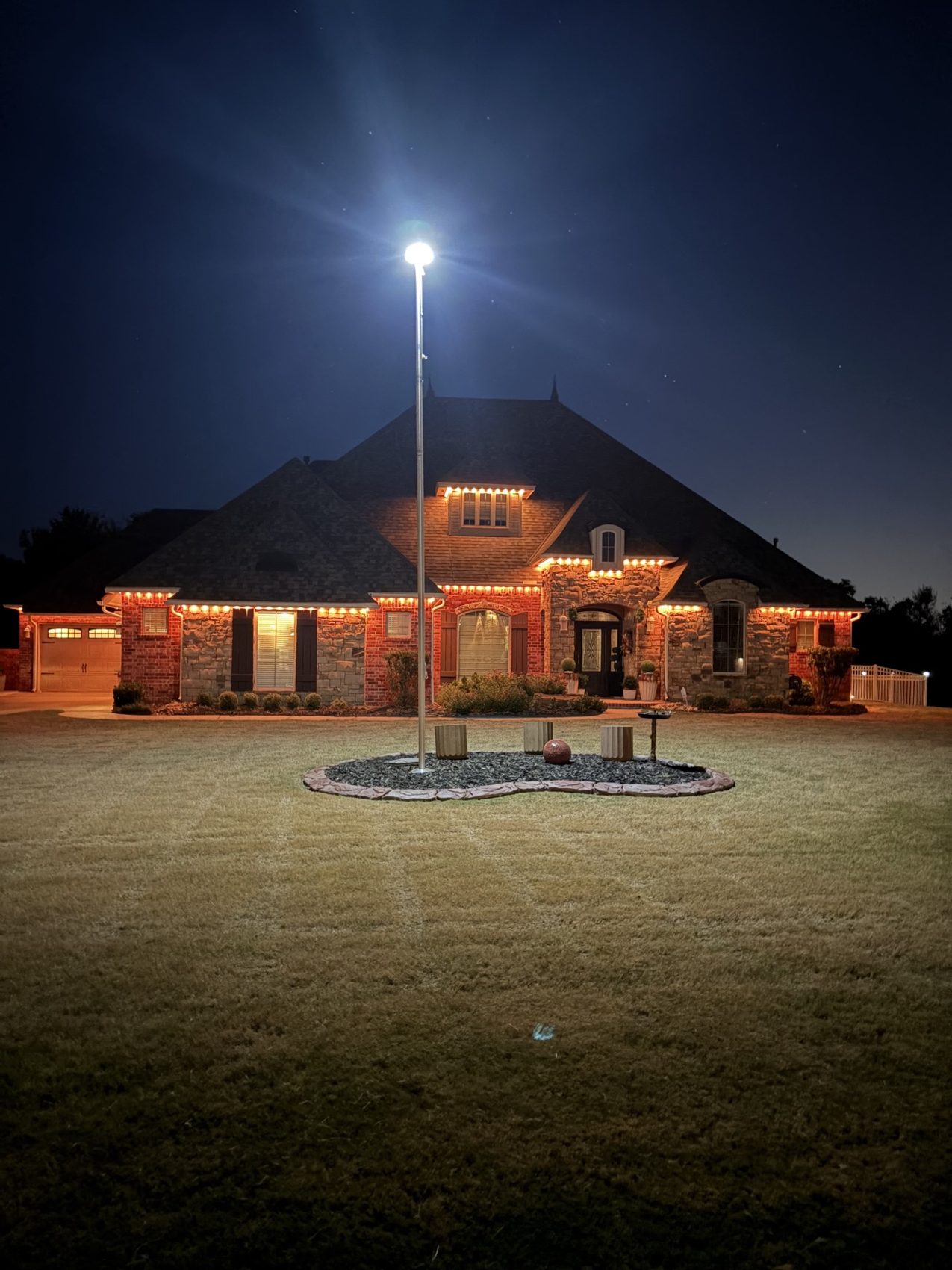 Home outlined in warm-white permanent roofline lighting at night
